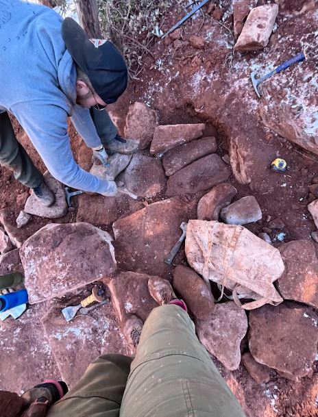 Workers standing on rocks, moving rocks