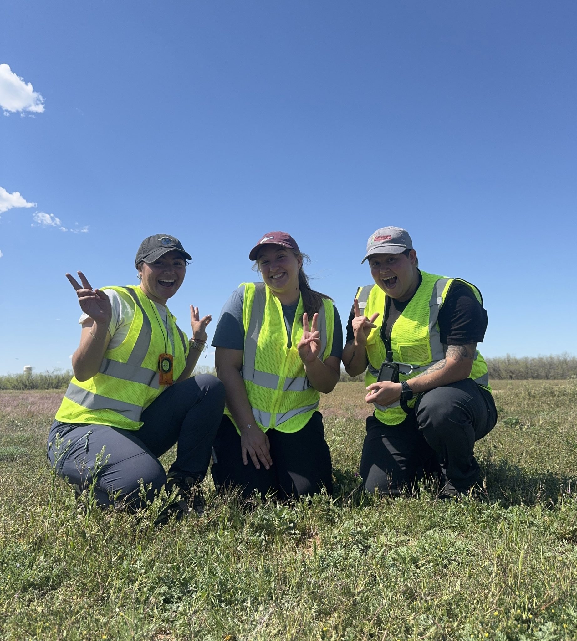 Jansy, Olivia, and Britt posing for a photo with milkweed.
