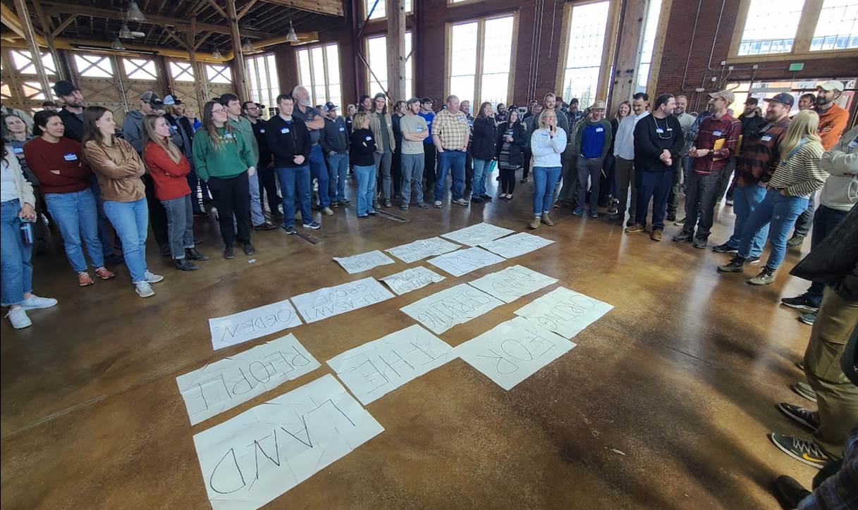 Group of Forest Service employees gathered around posters.