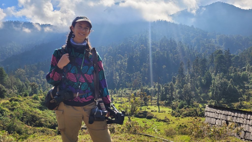 Annamaria Savrino, photographer, standing in a jungle with a camera.