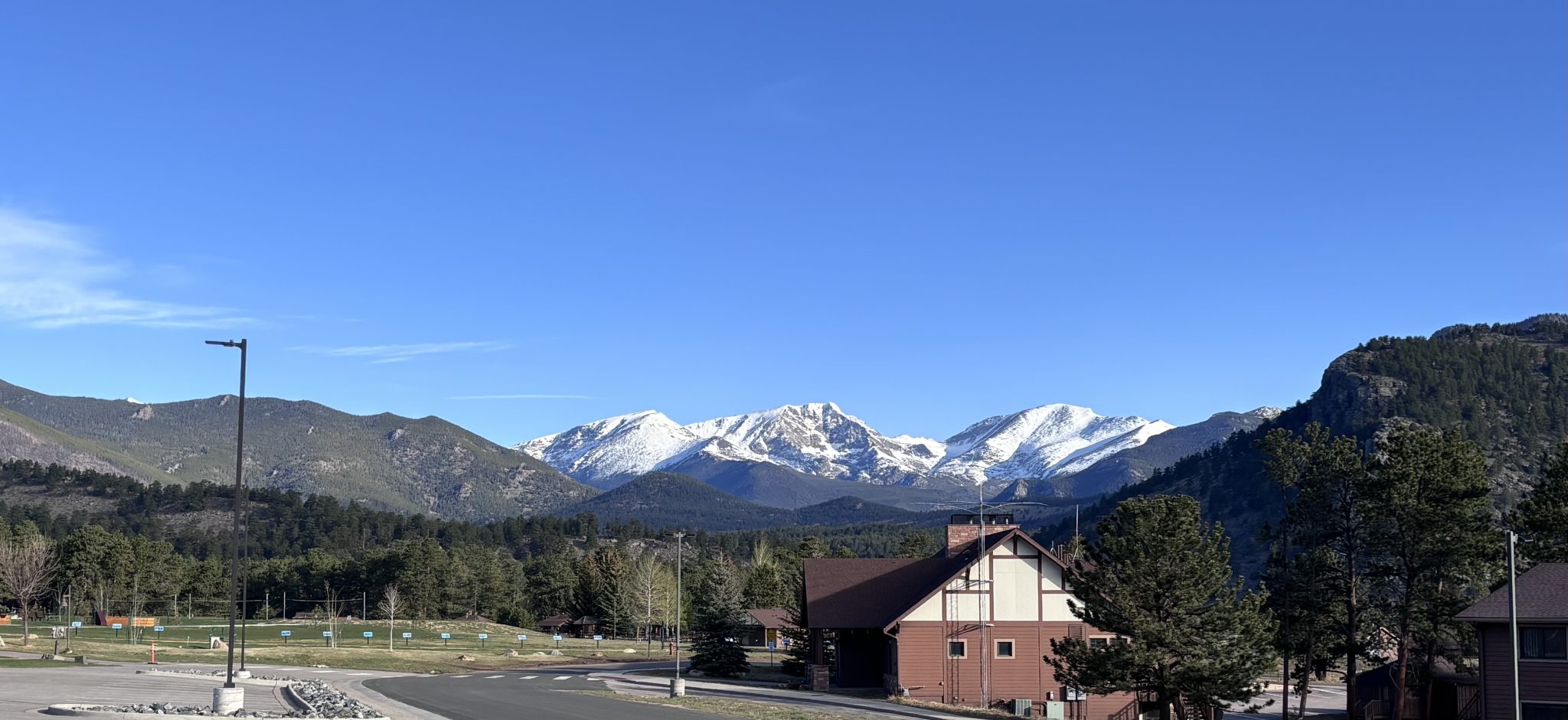 Rocky Mountains with white snow on peaks against a bright blue sky.
