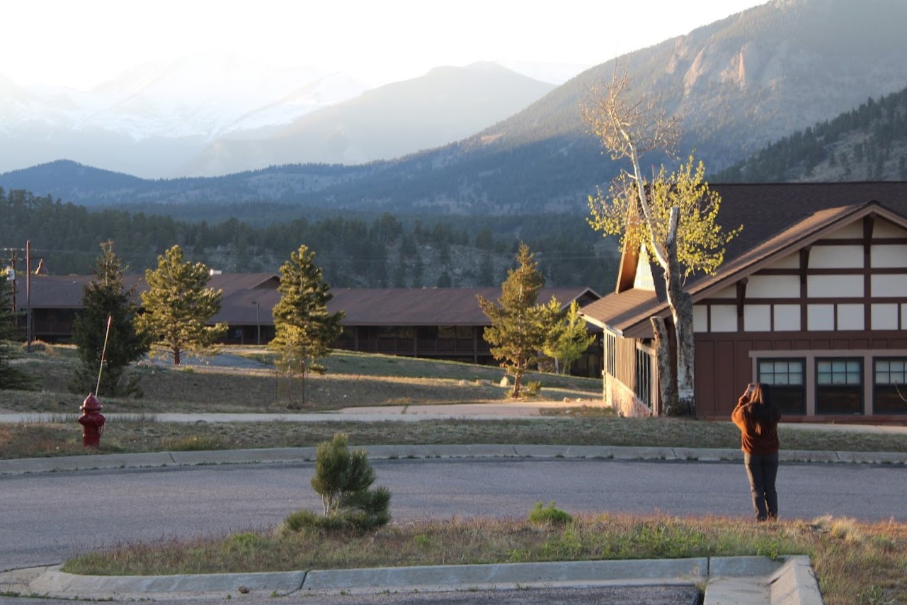 fish and feathers intern at YMCA of the Rockies looking through binoculars
